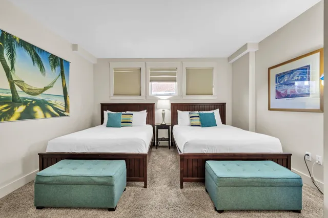 a bedroom with two beds and painting on the wall