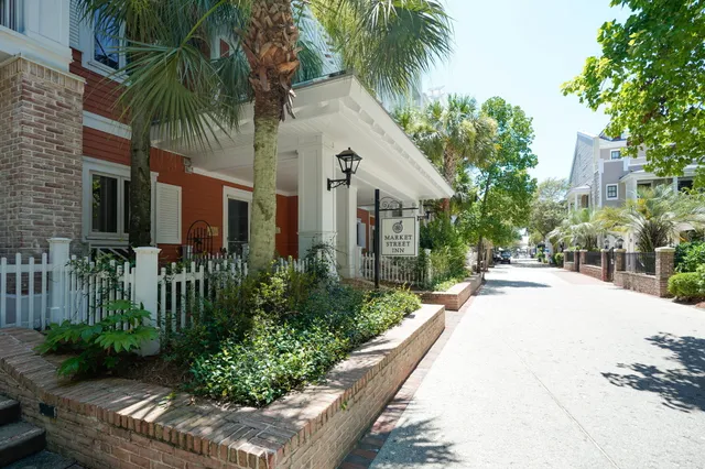a front view of a house with a yard and potted plants