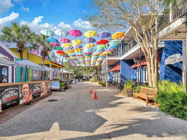 a multi story building with lots of trees and cars parked