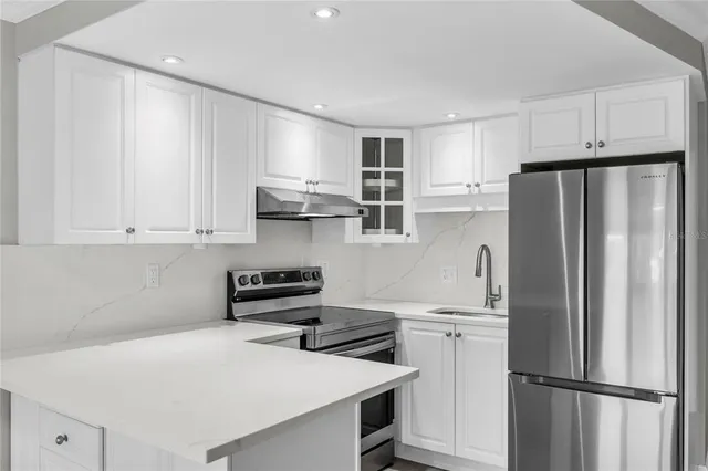 a kitchen with stainless steel appliances a refrigerator sink and cabinets