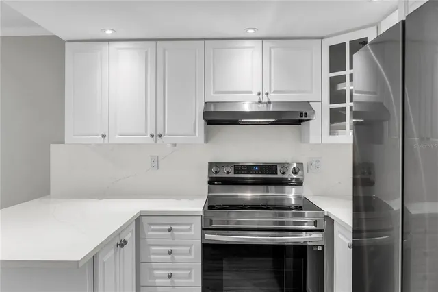 a kitchen with granite countertop a stove and a refrigerator