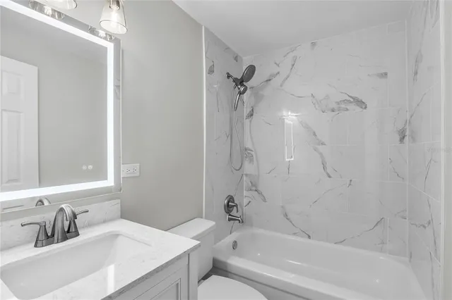 a bathroom with a sink toilet vanity and shower