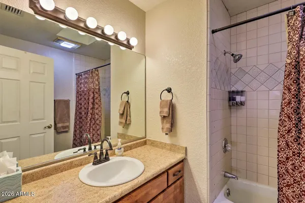 a bathroom with a granite countertop sink a mirror and a shower