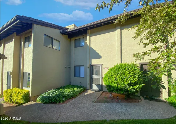 a yellow house with flower garden in front of it