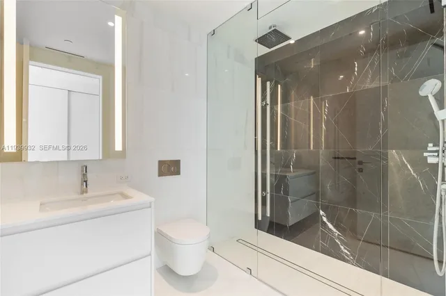 a white toilet sitting next to a shower