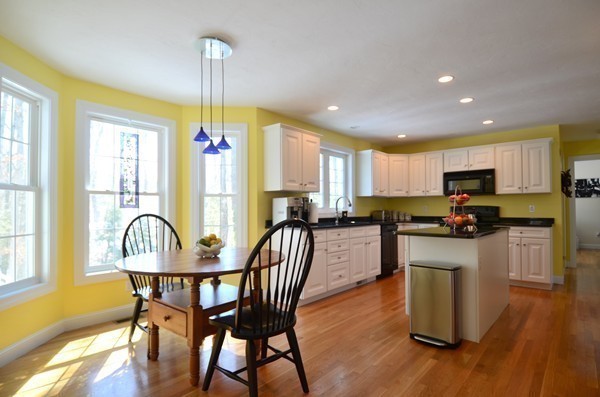 376 Mulpus Road Lunenburg, MA 01462 - Photo 3 of 27 a kitchen with granite countertop wooden floor dining table and stainless steel appliances