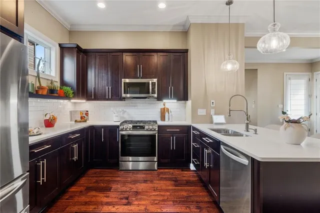 a kitchen with stainless steel appliances granite countertop a sink stove and refrigerator