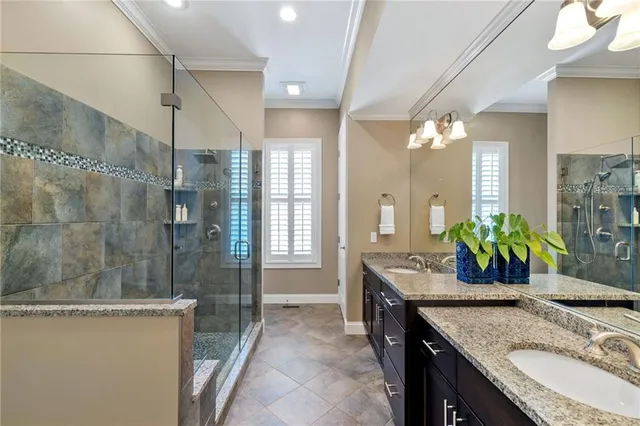 a bathroom with a granite countertop sink a mirror a bathtub and shower