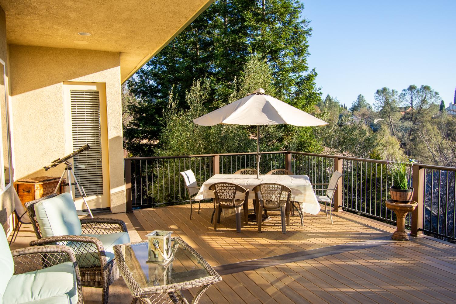 3388 Sudbury Road Cameron Park, CA 95682 - Photo 33 of 55 a view of a patio with a table and chairs under an umbrella with barbeque grill and wooden fence