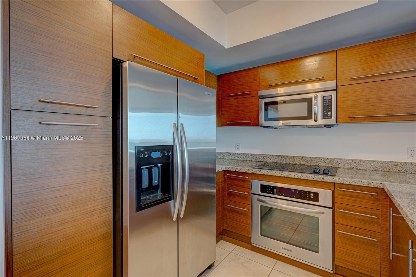 2641 North Flamingo Road, Unit 2307N Sunrise, FL 33323 - Photo 26 of 43 a kitchen with stainless steel appliances granite countertop a stove and a microwave