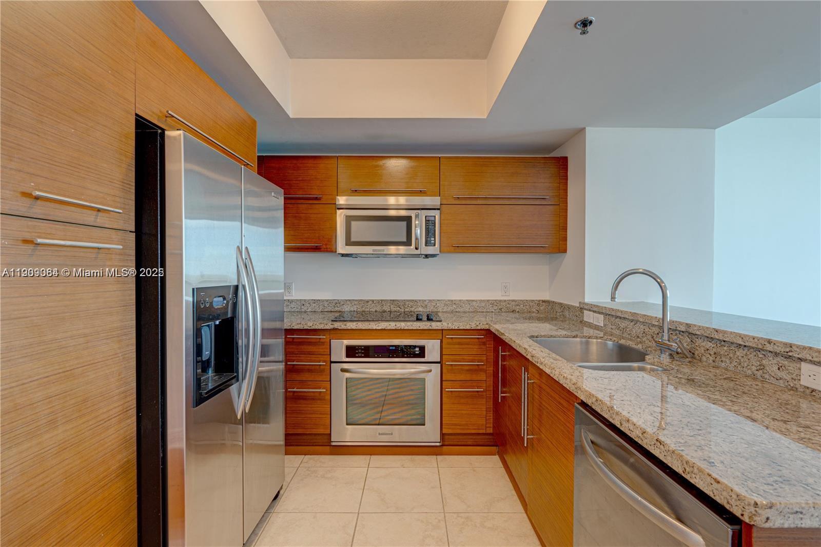 2641 North Flamingo Road, Unit 2307N Sunrise, FL 33323 - Photo 27 of 43 a kitchen with stainless steel appliances granite countertop a sink and cabinets