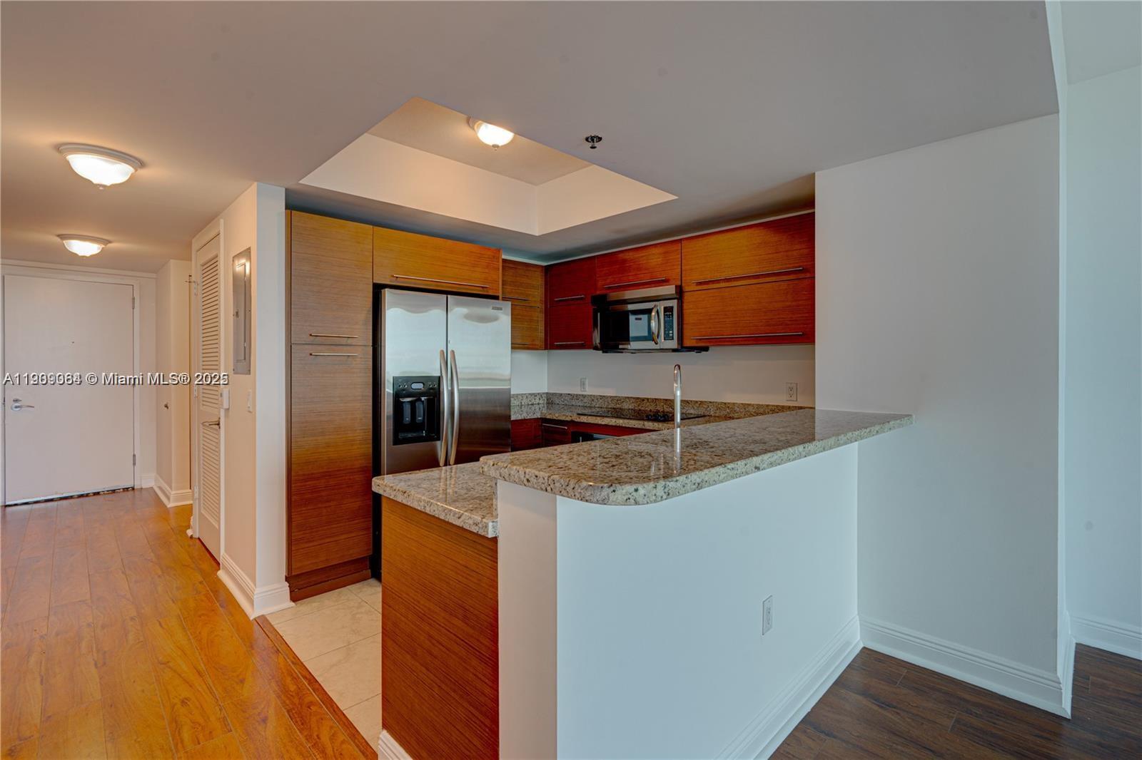 2641 North Flamingo Road, Unit 2307N Sunrise, FL 33323 - Photo 28 of 43 a kitchen with stainless steel appliances granite countertop a sink and a refrigerator