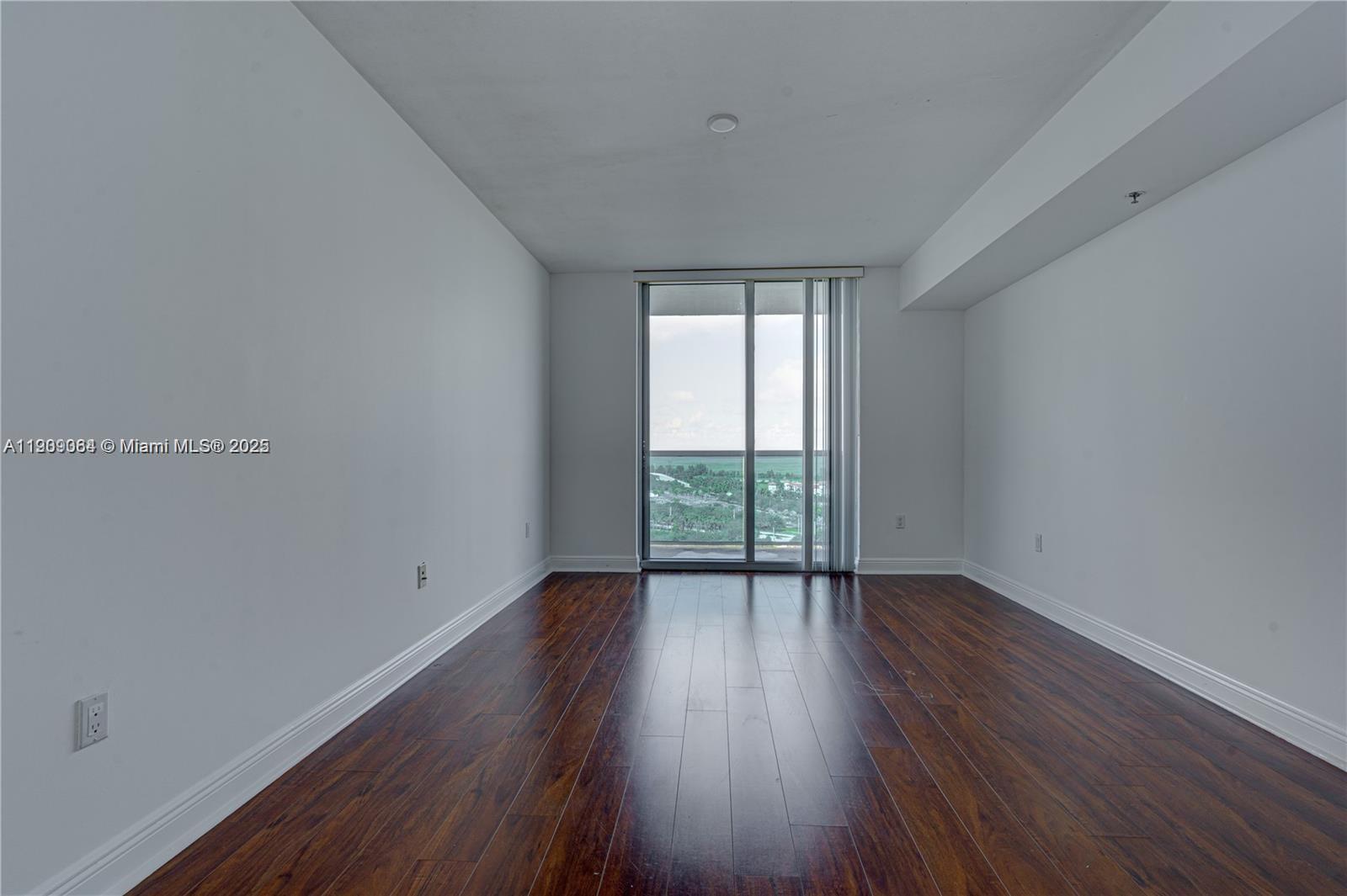 2641 North Flamingo Road, Unit 2307N Sunrise, FL 33323 - Photo 39 of 43 a view of an empty room with wooden floor and a window