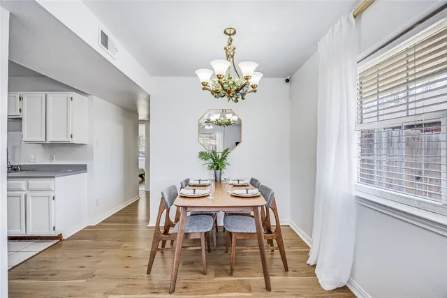 a dining room filled chandelier and wooden floor