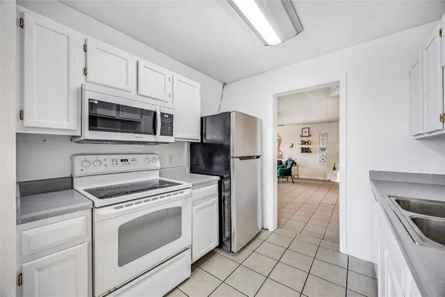 a kitchen with cabinets stainless steel appliances and a counter space