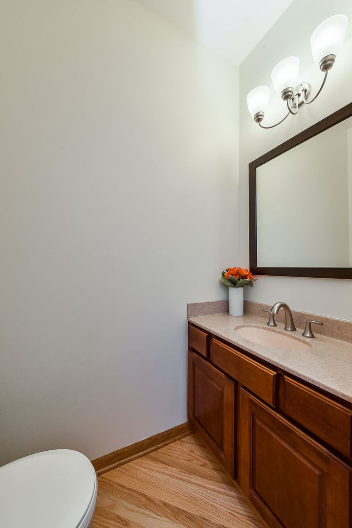 320 North Wright Street Naperville, IL 60540 - Photo 8 of 27 a bathroom with a toilet sink and mirror
