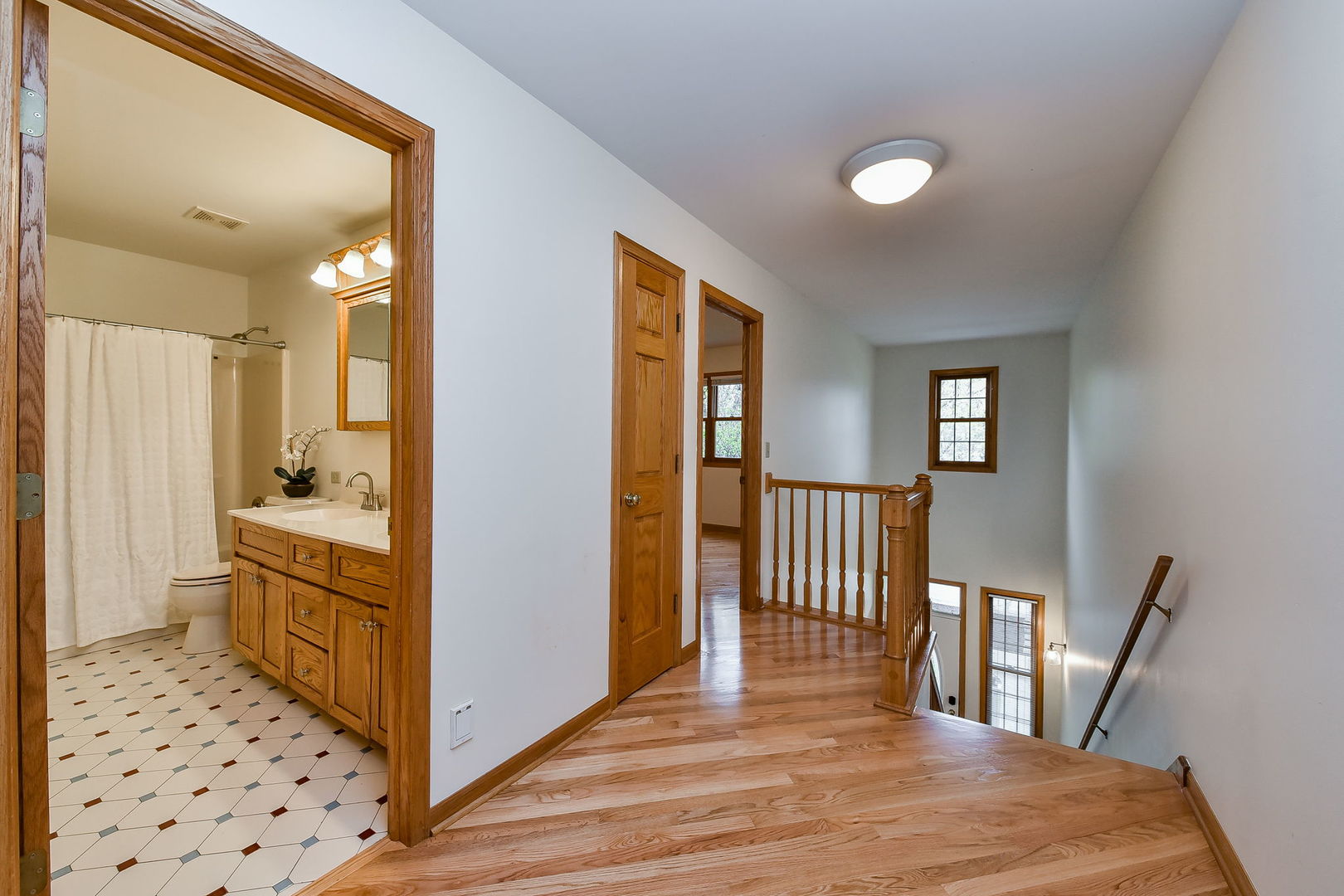 320 North Wright Street Naperville, IL 60540 - Photo 9 of 27 a view of a hallway with wooden floor and a bathroom