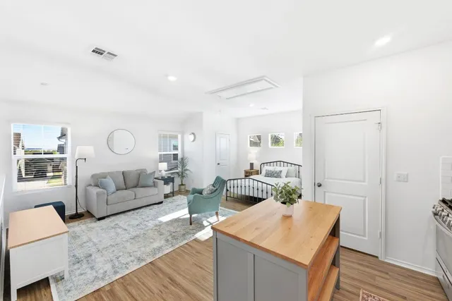 a living room with furniture white walls and wooden floor