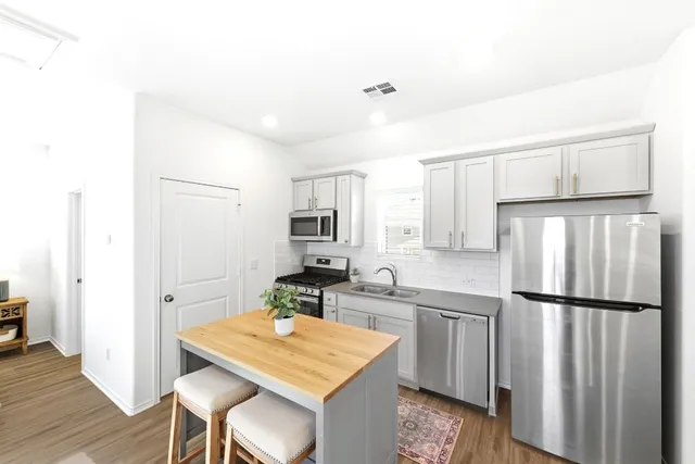 a kitchen with stainless steel appliances granite countertop a refrigerator sink and cabinets