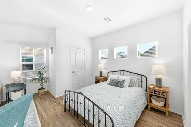 a bedroom with a bed and wooden floor