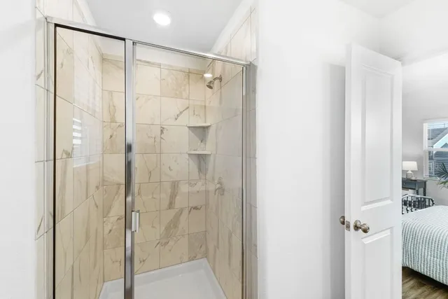 a bathroom with a shower and a glass door