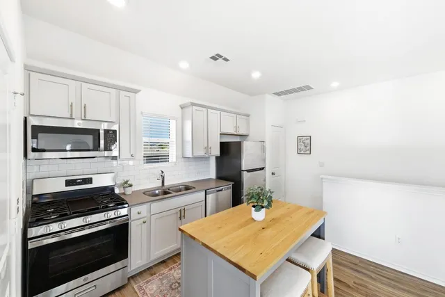 a kitchen with stainless steel appliances a stove microwave and refrigerator