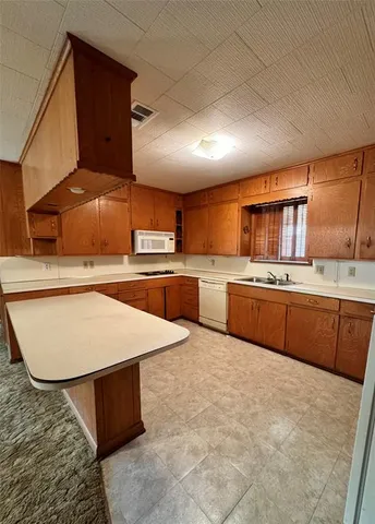 a kitchen with stainless steel appliances kitchen island a stove sink and cabinets