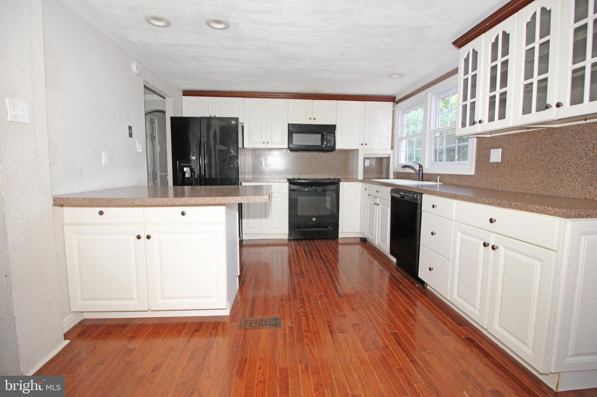 2 Twig Lane Willingboro, NJ 08046 - Photo 8 of 32 a kitchen with stainless steel appliances granite countertop a stove top oven a sink and white cabinets with wooden floor