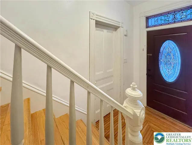 a view of entryway and hall with wooden floor