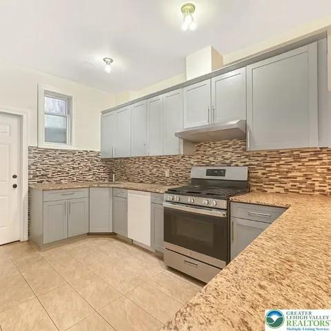 a kitchen with stainless steel appliances granite countertop a sink stove and cabinets
