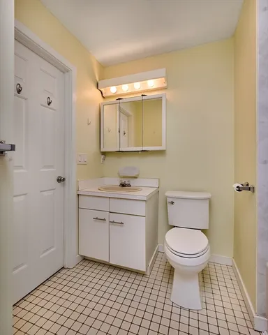 a bathroom with a granite countertop toilet a sink a mirror and vanity