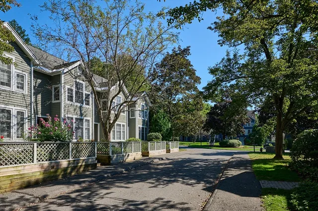 a front view of a house with a yard and trees