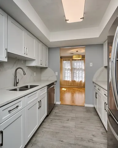 a kitchen with granite countertop a stove a sink and a refrigerator