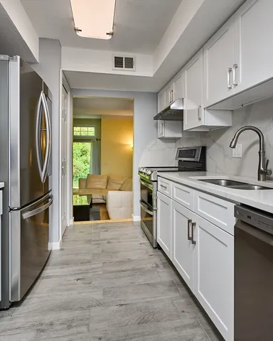 a kitchen with stainless steel appliances granite countertop a refrigerator sink and stove