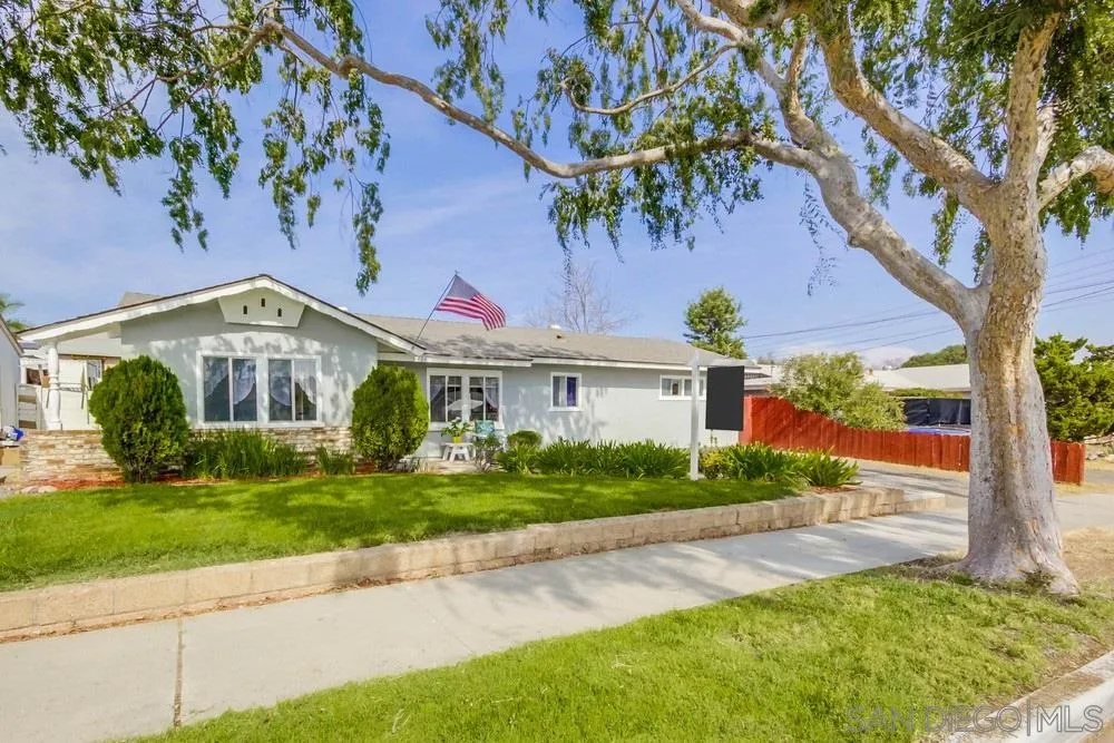 a front view of a house with a yard and potted plants
