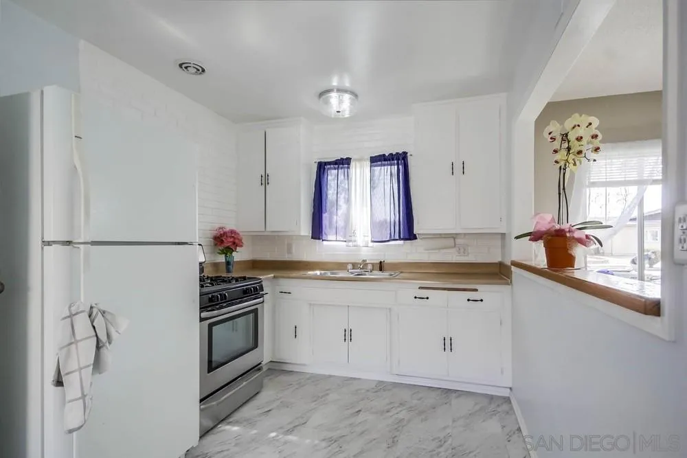 9464 Stoyer Drive Santee, CA 92071 - Photo 7 of 25 a kitchen with granite countertop cabinets stainless steel appliances and a sink