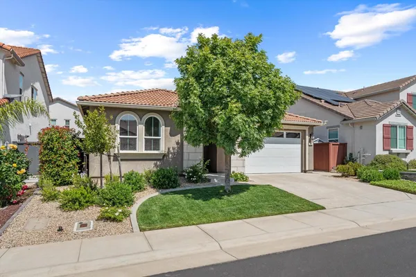 a front view of a house with a yard and a garage