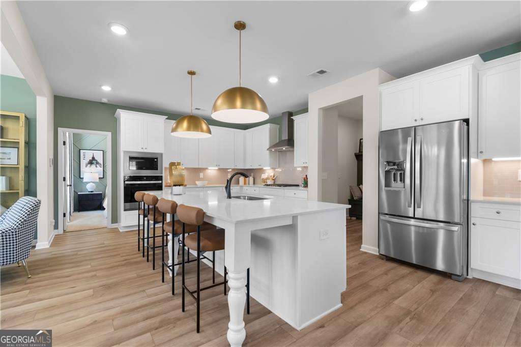 420 Hartsfield Road McDonough, GA 30253 - Photo 16 of 44 a kitchen with stainless steel appliances a dining table chairs refrigerator sink and cabinets