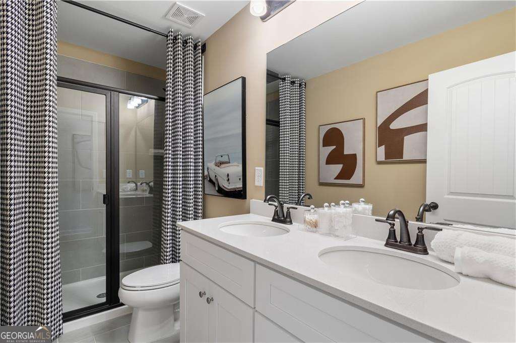 420 Hartsfield Road McDonough, GA 30253 - Photo 32 of 44 a bathroom with a toilet a sink and mirror