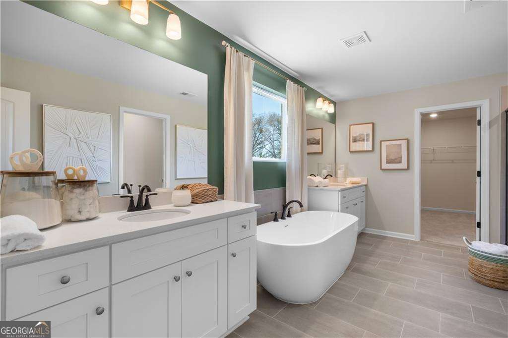 420 Hartsfield Road McDonough, GA 30253 - Photo 40 of 44 a bathroom with a white tub a sink and mirror