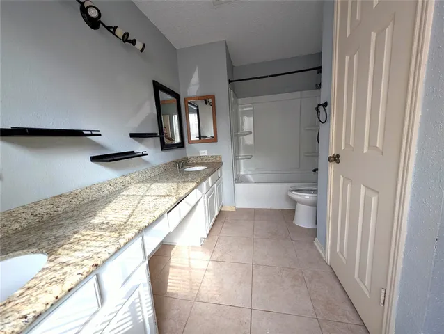a bathroom with a granite countertop sink a toilet and a shower