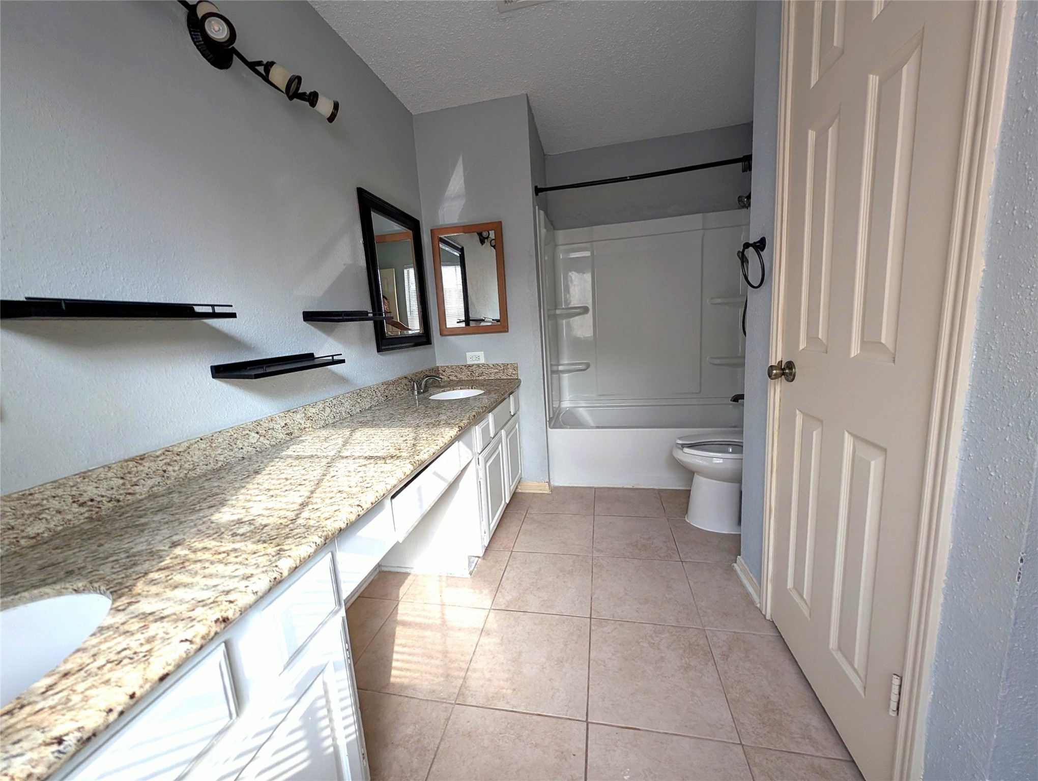 3219 Pecan Draw Court Sugar Land, TX 77479 - Photo 11 of 20 a bathroom with a granite countertop sink a toilet and a shower