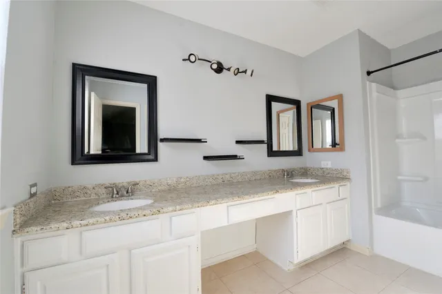 a bathroom with a granite countertop sink vanity and mirror