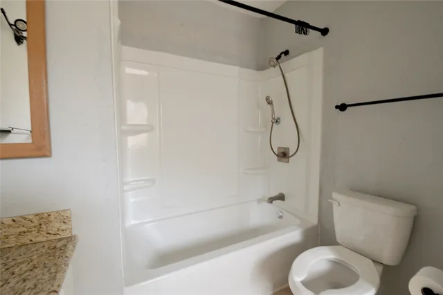 a bathroom with a toilet and a bath tub