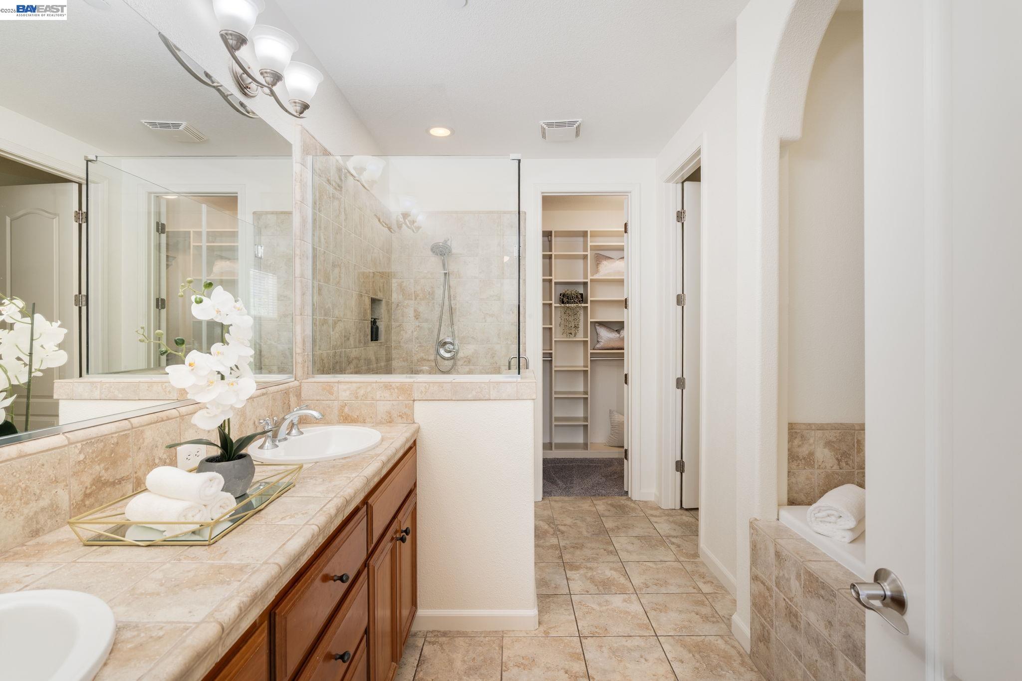 4653 Rimini Court Dublin, CA 94568 - Photo 26 of 44 a spacious bathroom with a granite countertop sink a mirror and a shower