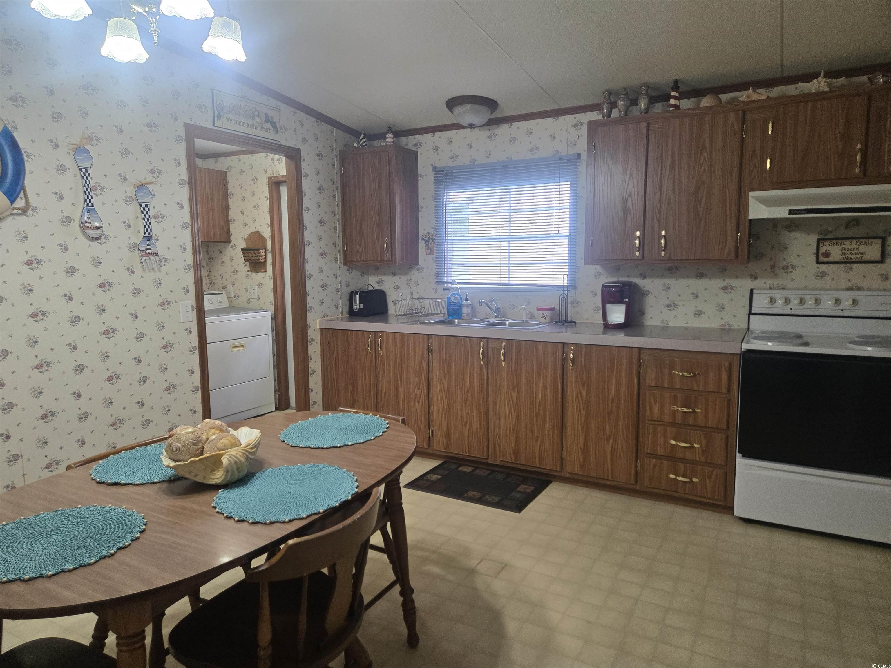 326 Tunnoch Road Murrells Inlet, SC 29576 - Photo 11 of 22 Kitchen with electric stove, light countertops, crown molding, washer / dryer, and range hood