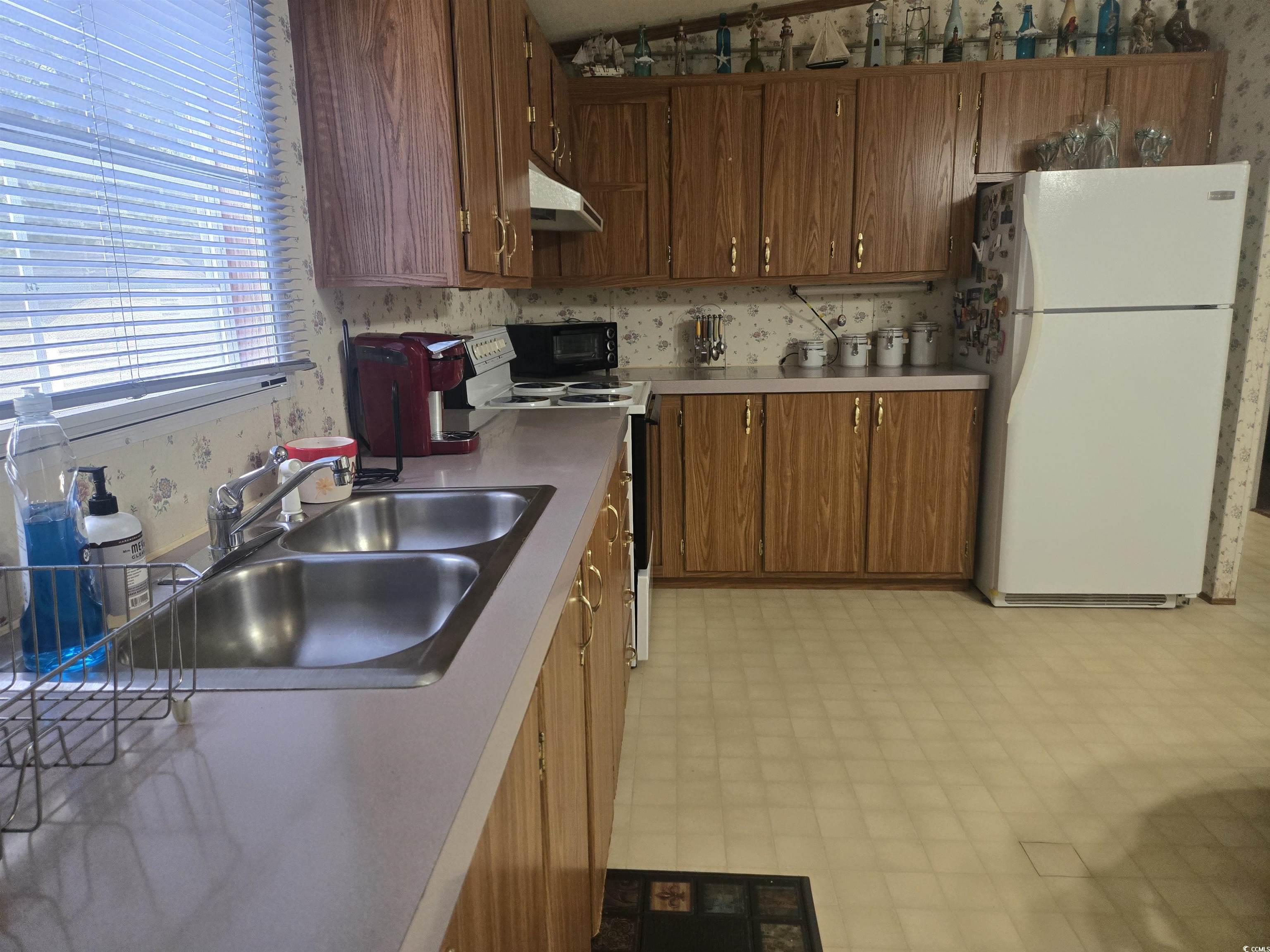 326 Tunnoch Road Murrells Inlet, SC 29576 - Photo 12 of 22 Kitchen featuring wallpapered walls, freestanding refrigerator, electric range, under cabinet range hood, and light floors