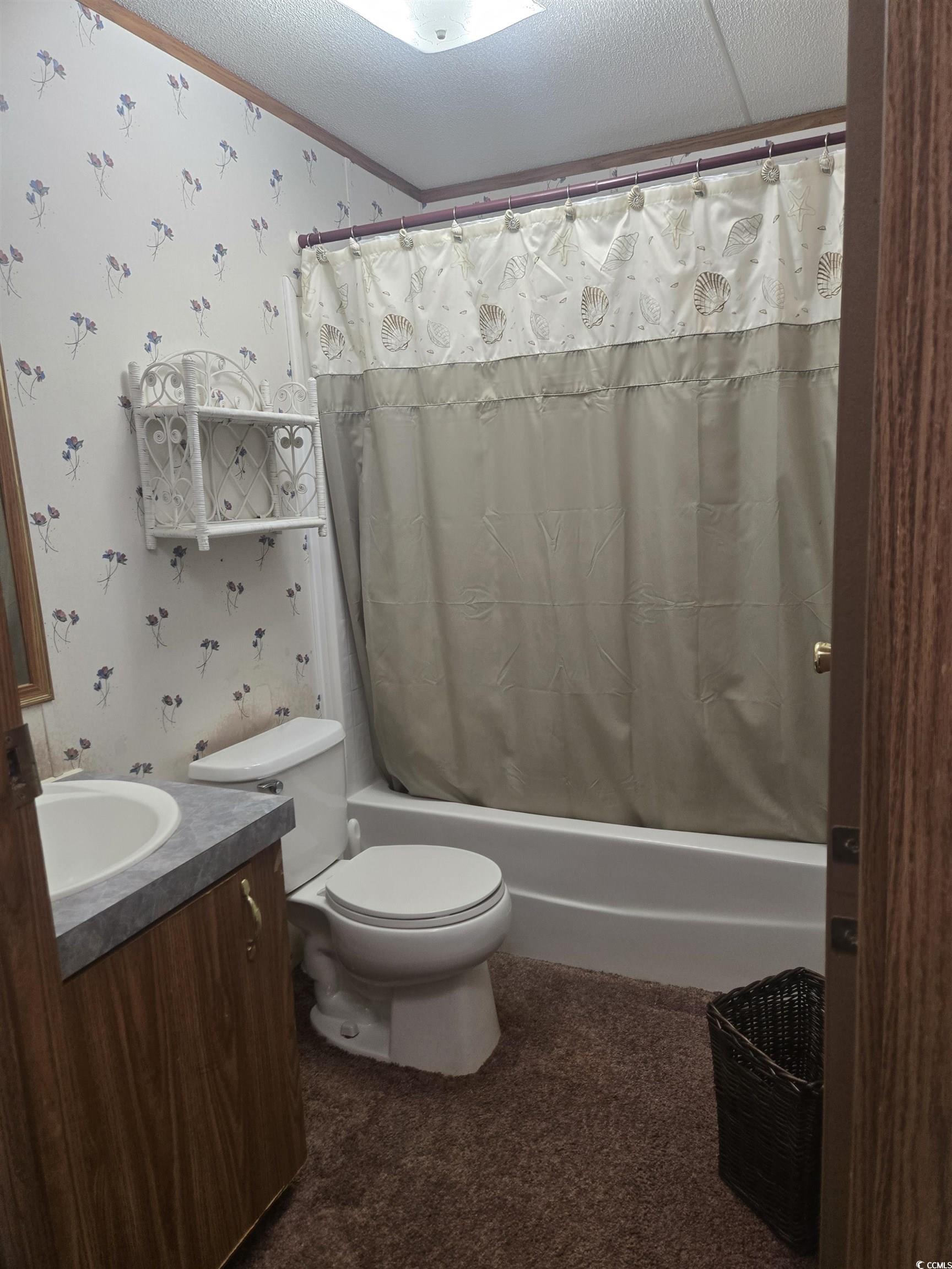 326 Tunnoch Road Murrells Inlet, SC 29576 - Photo 17 of 22 Bathroom with wallpapered walls, vanity, a textured ceiling, and shower / tub combo
