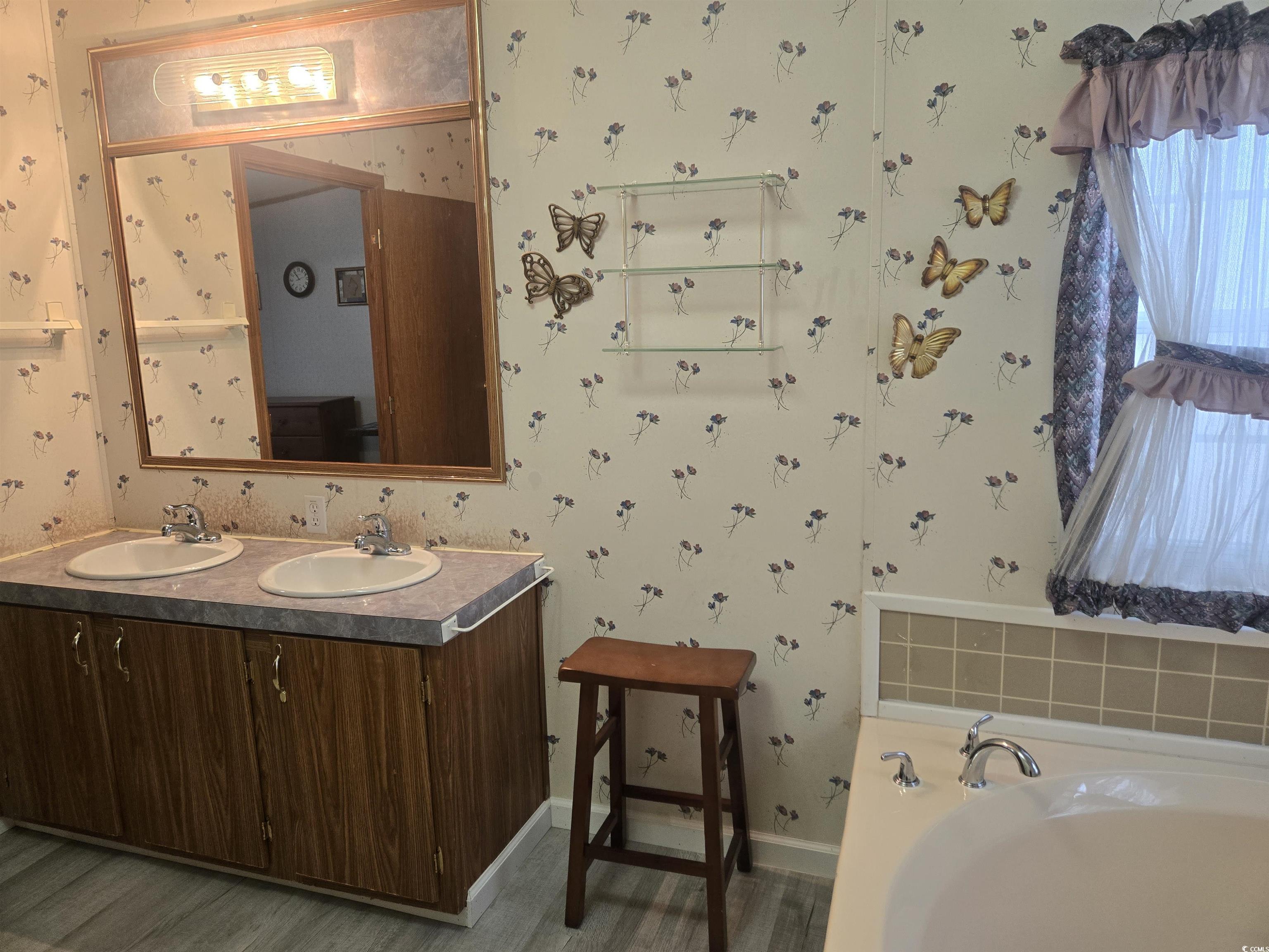 326 Tunnoch Road Murrells Inlet, SC 29576 - Photo 20 of 22 Full bath featuring double vanity, wallpapered walls, a garden tub, and wood finished floors