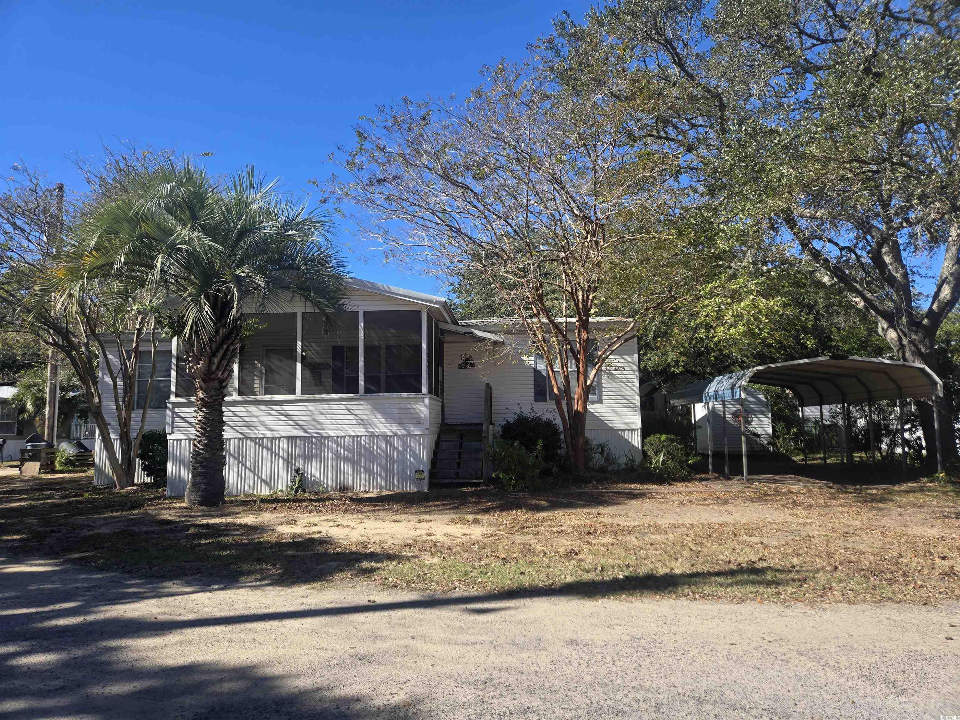 326 Tunnoch Road Murrells Inlet, SC 29576 - Photo 2 of 22 View of side of property with a sunroom and a carport